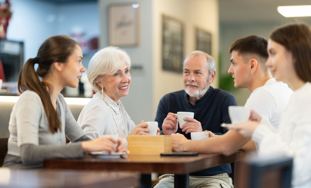 A family of five talking over coffee around a table