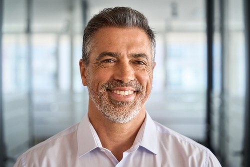 A middle-aged man smiling in an office